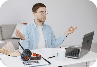 Jonge man mediteert aan zijn bureau, studeert op zijn laptop, concentreert zich en probeert stress onder controle te houden tijdens het online leren.